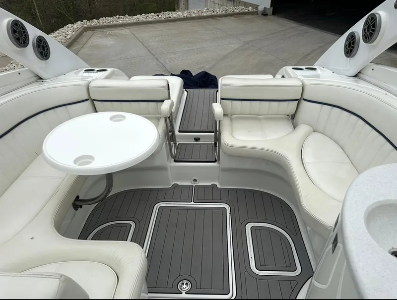 Slide: The Image of 2005 Cobalt 360 boat interior with white seating, round table, and gray flooring. - 10