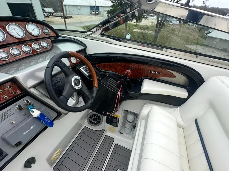 Slide: The Image of Interior of a 2005 Cobalt 360 boat, featuring a sleek dashboard and steering wheel. - 7