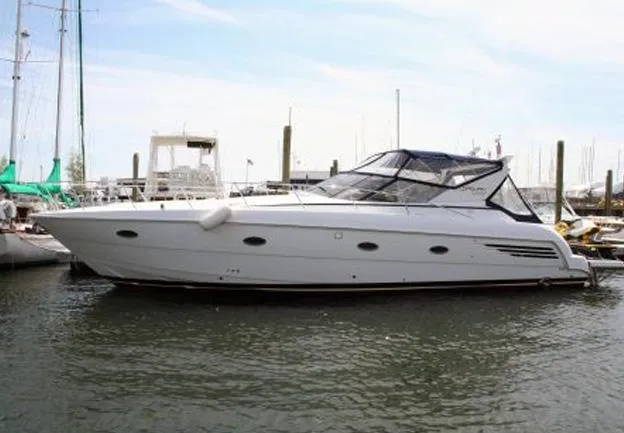 Slide: The Image of 2000 Carver 440 Hardtop Express yacht docked in marina, side view. - 2