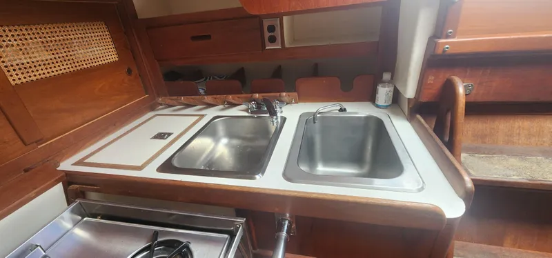 Slide: The Image of 1982 Tartan 37 yacht kitchen with dual sinks and wooden cabinetry. - 11