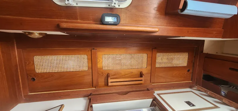 Slide: The Image of Interior of a 1982 Tartan 37 sailboat with wooden cabinetry and woven paneling. - 14