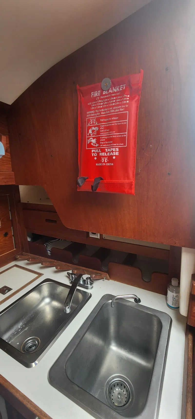 Slide: The Image of 1982 Tartan 37 yacht kitchen with dual sinks and fire blanket on wooden wall. - 15