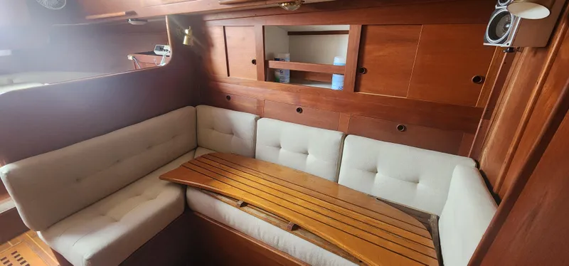 Slide: The Image of Cozy interior of 1982 Tartan 37 sailboat with wooden table and cushioned seating. - 18