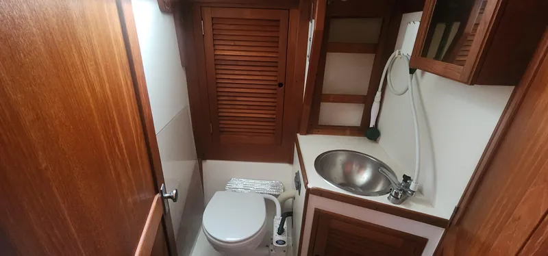 Slide: The Image of 1982 Tartan 37 yacht bathroom with wooden cabinetry, sink, and toilet. - 22