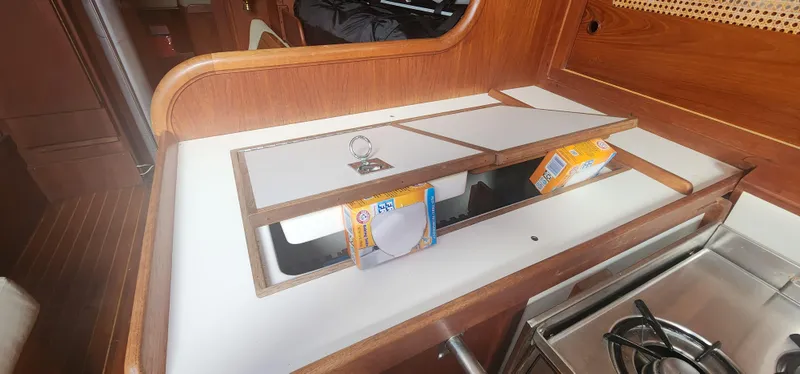 Slide: The Image of 1982 Tartan 37 yacht kitchen with wooden cabinetry and storage compartments. - 27
