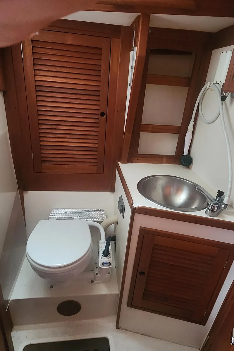 Slide: The Image of Compact bathroom in 1982 Tartan 37 sailboat with wooden cabinets and stainless steel sink. - 32
