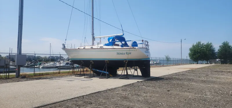 Slide: The Image of 1982 Tartan 37 sailboat on stands near marina, clear sky, and waterfront view. - 35
