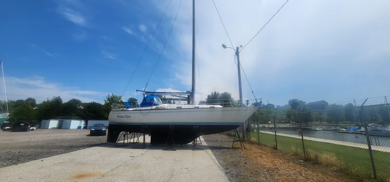 Slide: The Image of 1982 Tartan 37 sailboat on land, clear sky, marina background. - 37