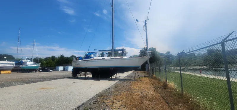 Slide: The Image of Tartan 37 sailboat from 1982 on dry dock under a clear blue sky. - 38