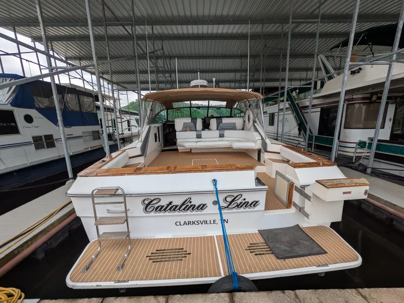 Slide: The Image of 1988 Sea Ray 460 Express Cruiser docked, featuring spacious deck and seating area. - 11