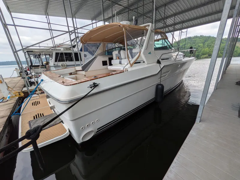 Slide: The Image of 1988 Sea Ray 460 Express Cruiser docked under a covered marina. - 13