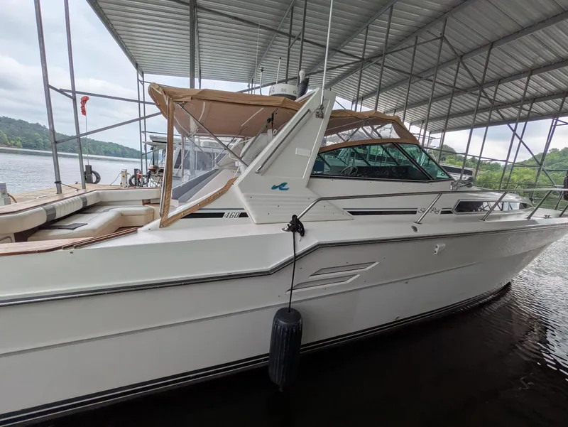 Slide: The Image of 1988 Sea Ray 460 Express Cruiser docked under a covered marina. - 15