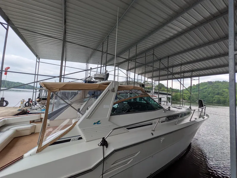 Slide: The Image of 1988 Sea Ray 460 Express Cruiser docked under a covered marina. - 16