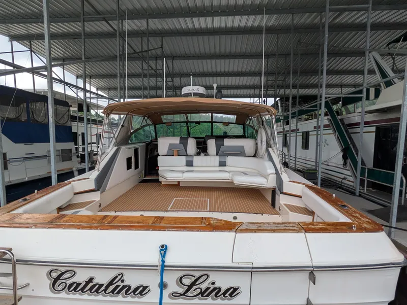 Slide: The Image of 1988 Sea Ray 460 Express Cruiser docked, featuring spacious deck and seating area. - 19