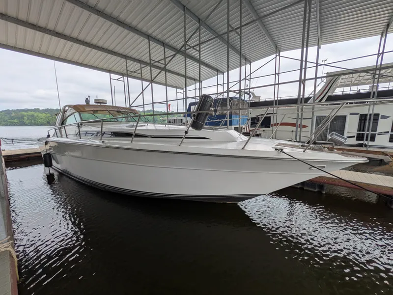 Slide: The Image of 1988 Sea Ray 460 Express Cruiser docked under a covered marina. - 2