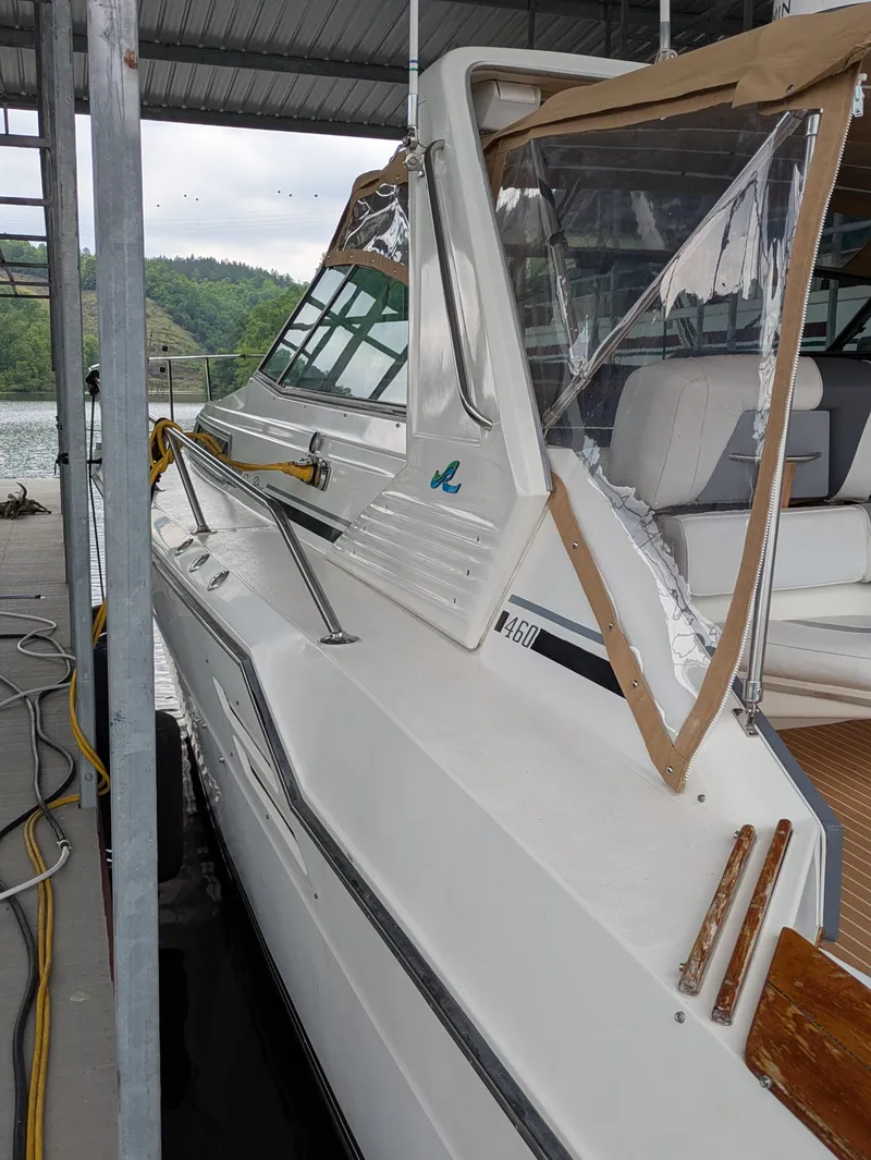 Slide: The Image of 1988 Sea Ray 460 Express Cruiser docked under a covered marina. - 20