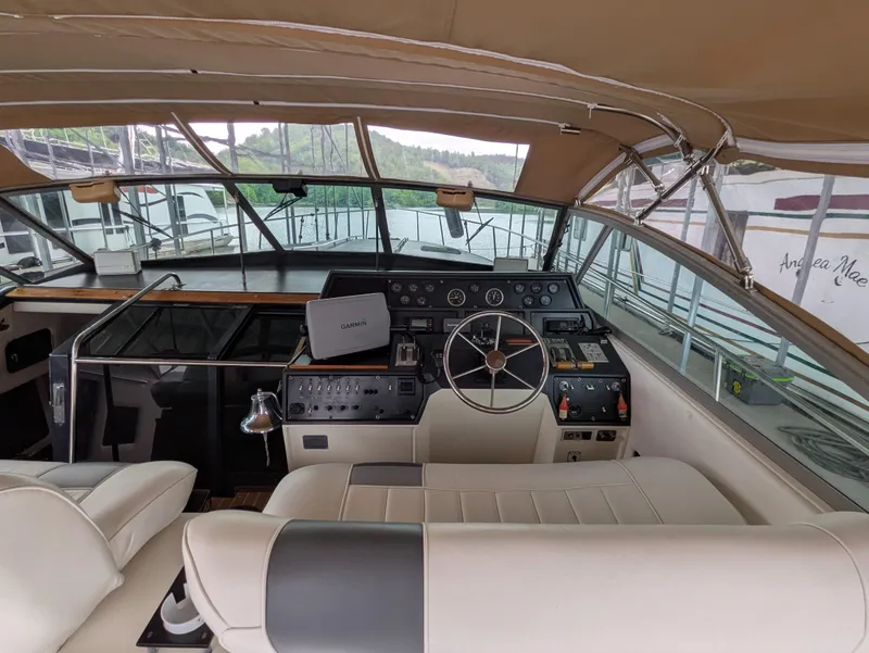Slide: The Image of 1988 Sea Ray 460 Express Cruiser helm with beige seating and navigation equipment. - 21
