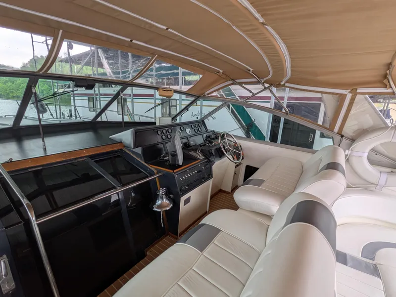 Slide: The Image of 1988 Sea Ray 460 Express Cruiser helm with beige seating and controls. - 22