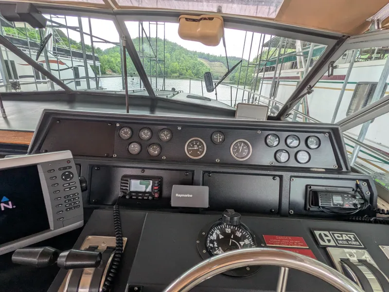 Slide: The Image of 1988 Sea Ray 460 Express Cruiser helm with gauges, navigation equipment, and scenic waterway view. - 25