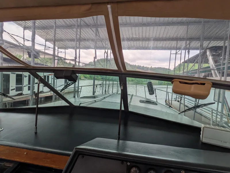 Slide: The Image of 1988 Sea Ray 460 Express Cruiser helm view under covered dock. - 30