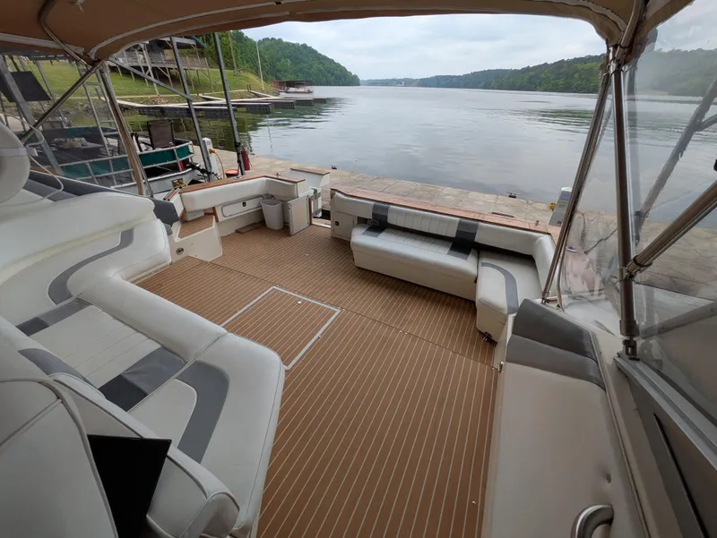 Slide: The Image of 1988 Sea Ray 460 Express Cruiser with spacious deck overlooking serene lake view. - 31