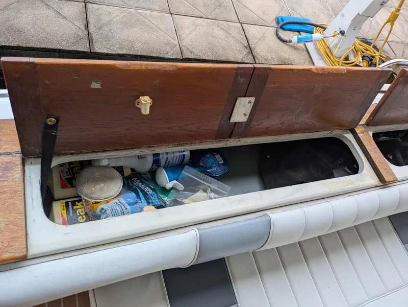 Slide: The Image of Storage compartment on a 1988 Sea Ray 460 Express Cruiser, containing various boating supplies. - 35