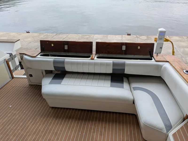 Slide: The Image of 1988 Sea Ray 460 Express Cruiser with sleek seating and waterfront view. - 37