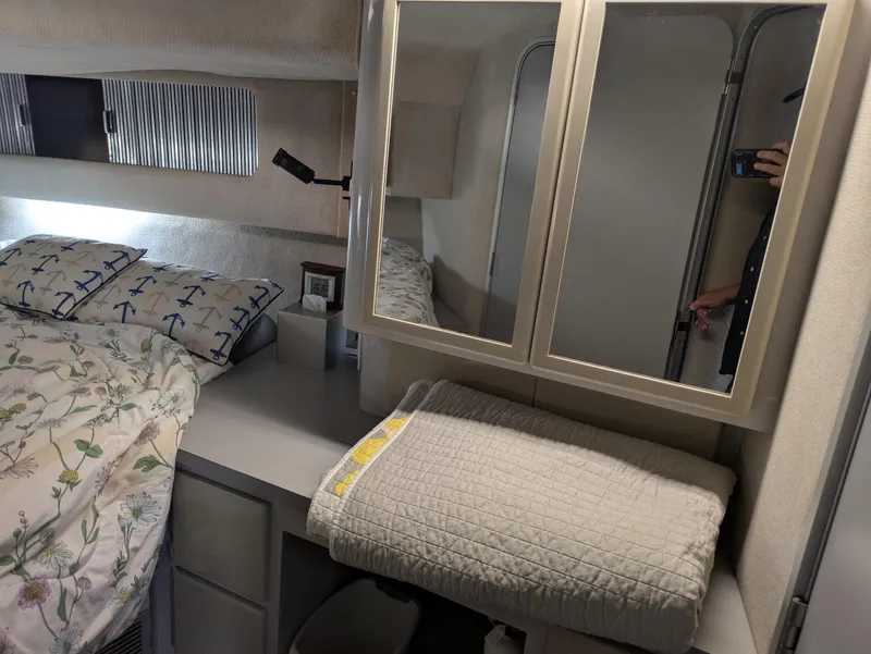 Slide: The Image of 1988 Sea Ray 460 Express Cruiser cabin with bed, mirror, and storage area. - 42