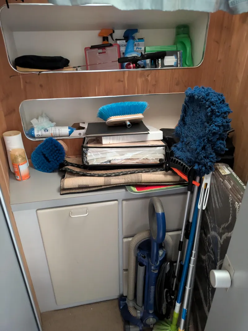 Slide: The Image of Storage area in a 1988 Sea Ray 460 Express Cruiser with cleaning supplies and equipment. - 44