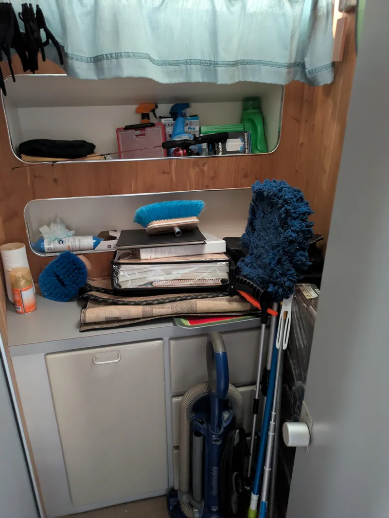 Slide: The Image of Storage area on a 1988 Sea Ray 460 Express Cruiser with cleaning supplies and equipment. - 45