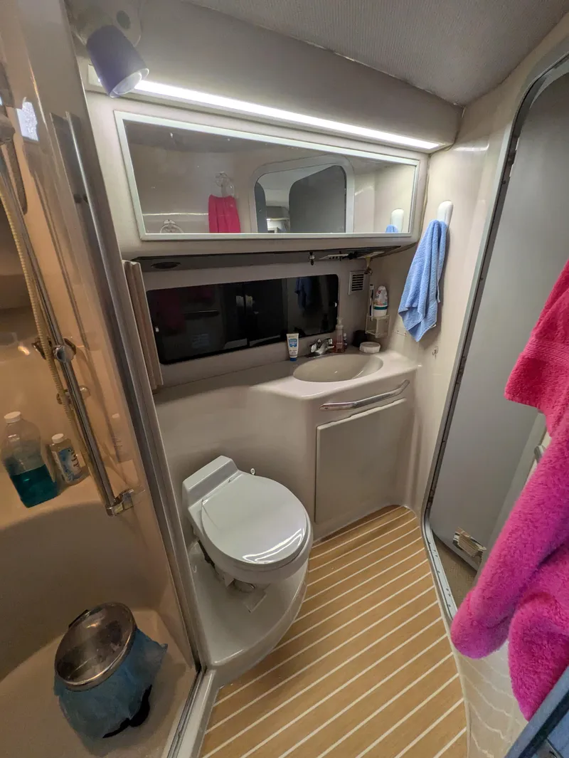 Slide: The Image of 1988 Sea Ray 460 Express Cruiser bathroom with modern amenities and wooden flooring. - 46