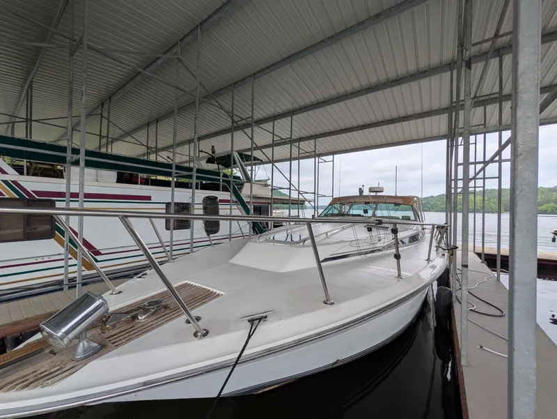 Slide: The Image of 1988 Sea Ray 460 Express Cruiser docked under a covered marina. - 6