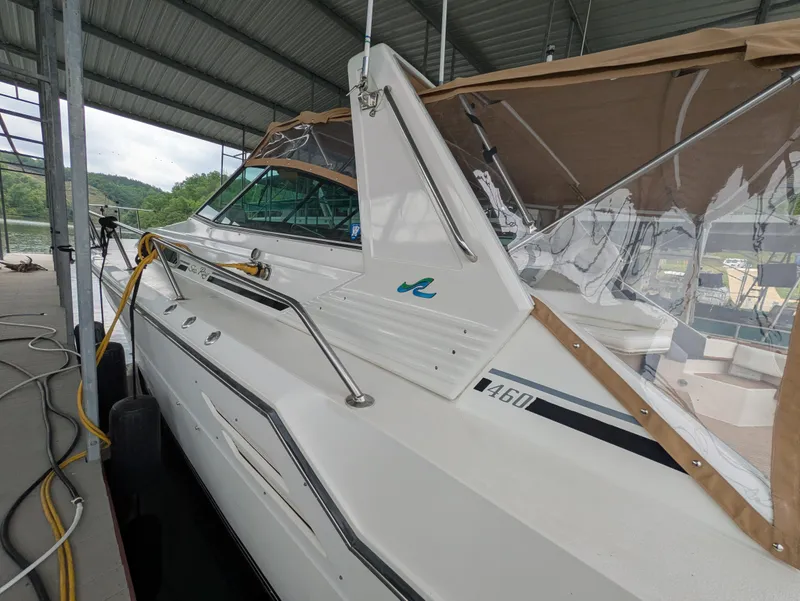 Slide: The Image of 1988 Sea Ray 460 Express Cruiser docked under a covered marina. - 7