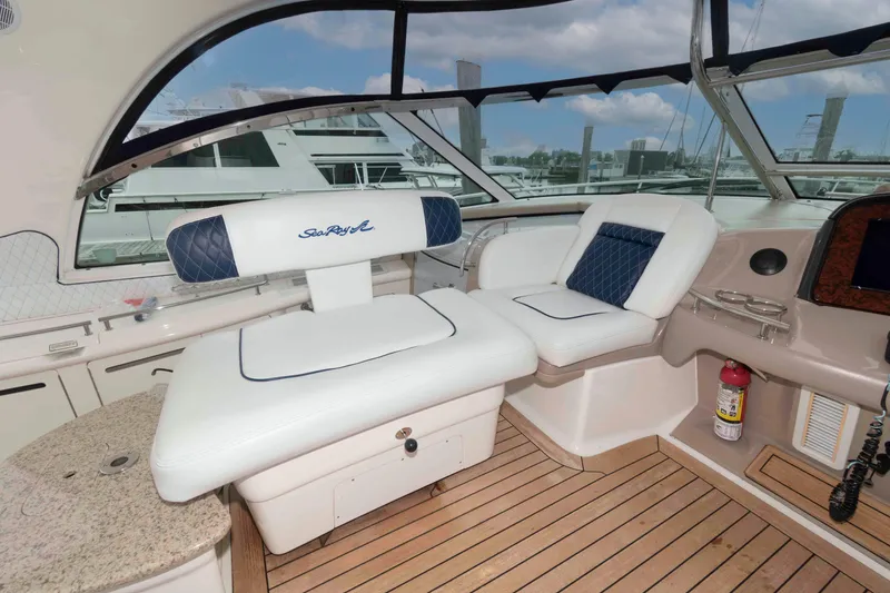 Slide: The Image of 2005 Sea Ray 500 Sundancer yacht interior with white seating and wooden flooring. - 11