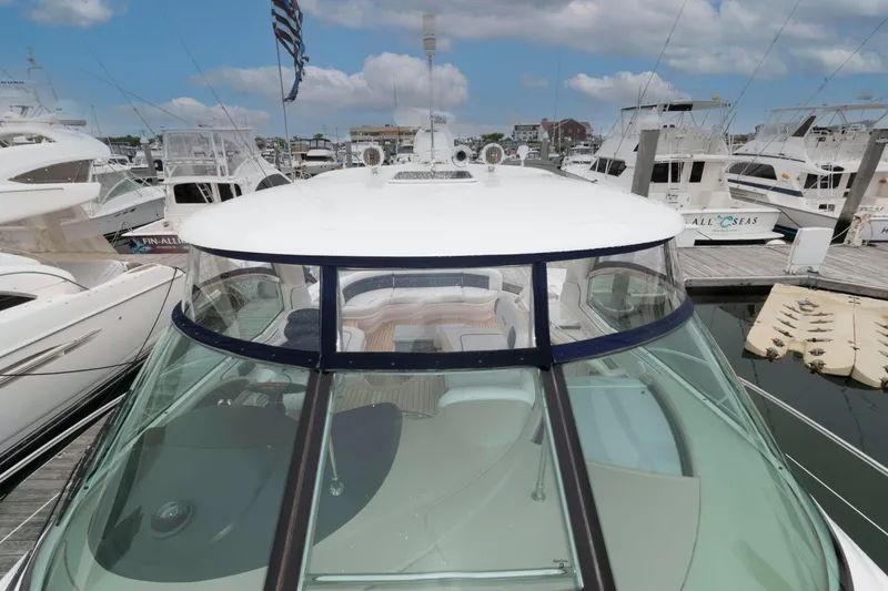 Slide: The Image of 2005 Sea Ray 500 Sundancer yacht docked at a marina under a partly cloudy sky. - 12