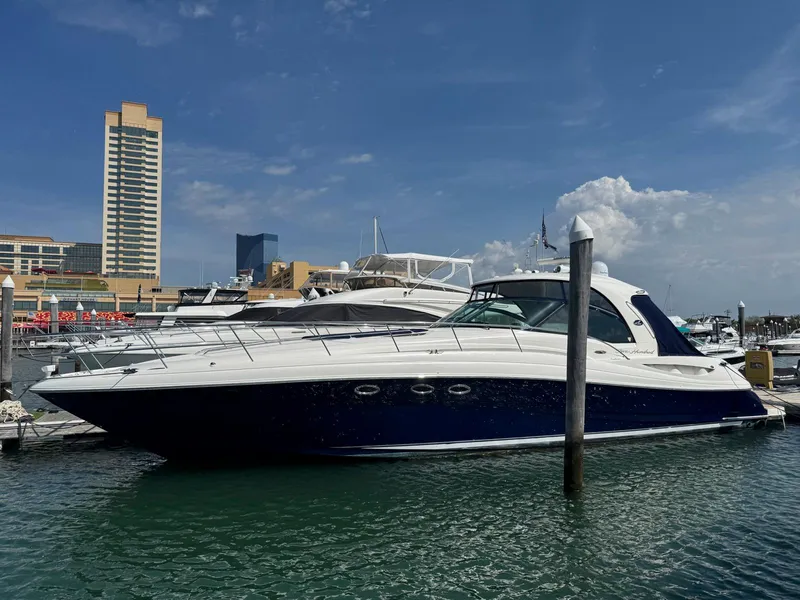 Slide: The Image of 2005 Sea Ray 500 Sundancer yacht docked in a marina under a clear blue sky. - 2