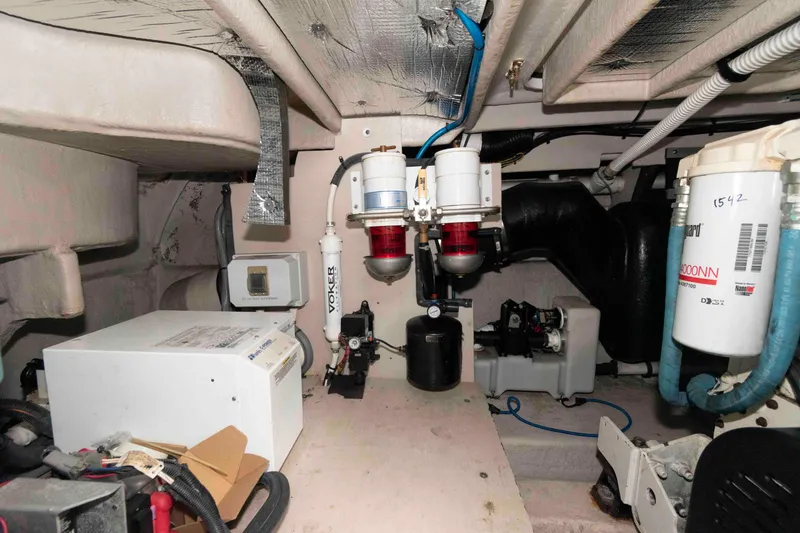 Slide: The Image of Engine room of 2005 Sea Ray 500 Sundancer with various mechanical components and filters. - 28