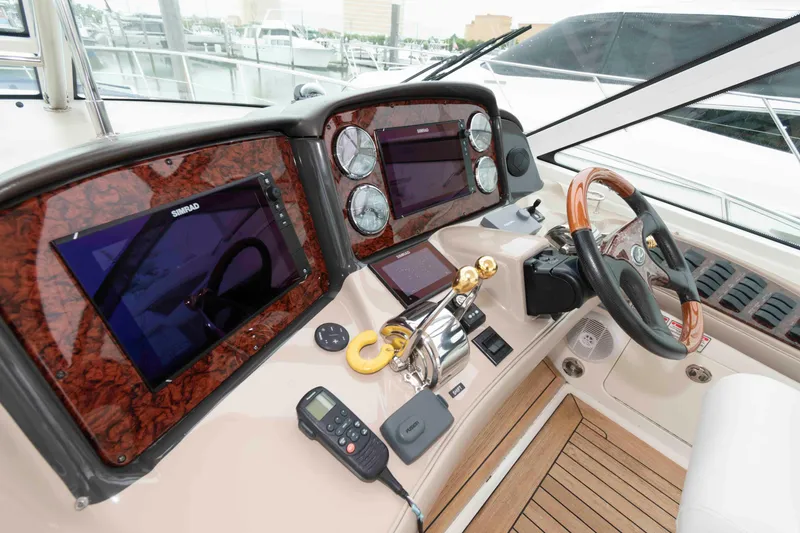 Slide: The Image of Control panel of a 2005 Sea Ray 500 Sundancer yacht with navigation instruments and steering wheel. - 9
