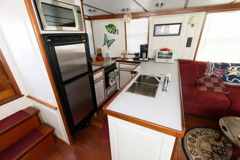 Slide: The Image of Interior of 1997 Florida Bay Coasters 35, featuring kitchen and cozy seating area. - 17