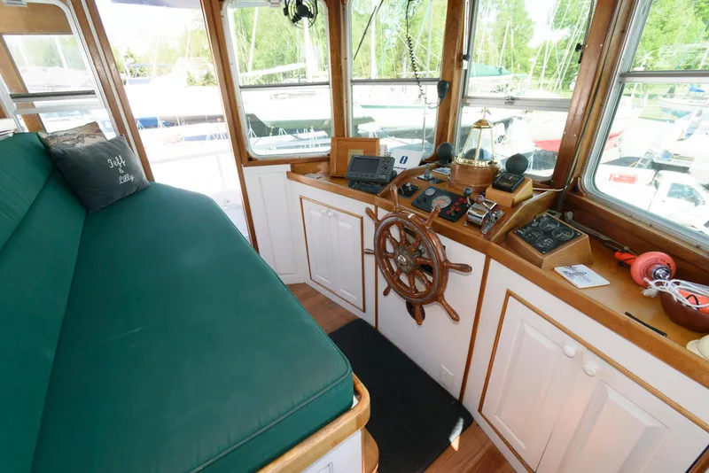 Slide: The Image of 1997 Florida Bay Coasters 35 interior with green seating, wooden helm, and navigation equipment. - 26