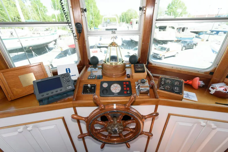 Slide: The Image of Helm of 1997 Florida Bay Coasters 35, featuring navigation instruments and wooden steering wheel. - 27