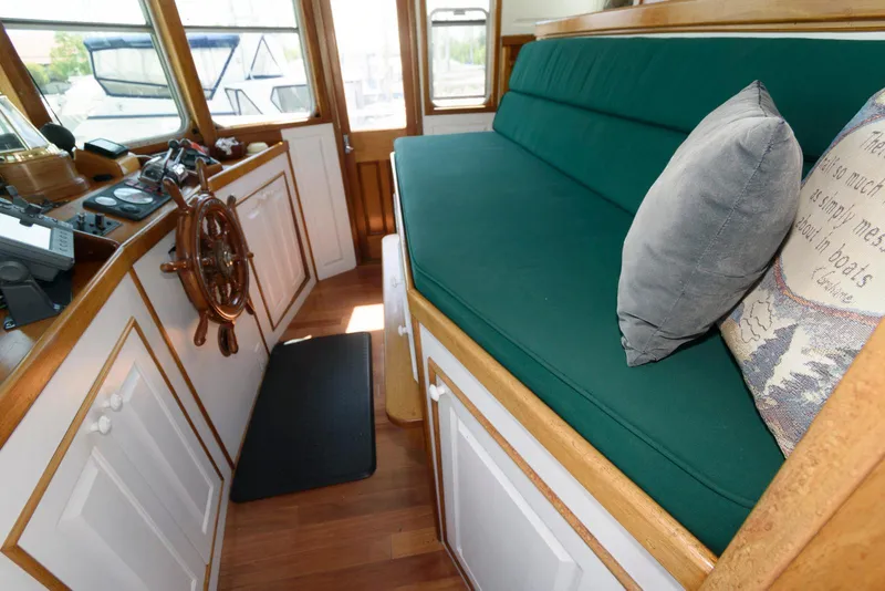 Slide: The Image of Interior of a 1997 Florida Bay Coasters 35 boat with green seating and wooden accents. - 29