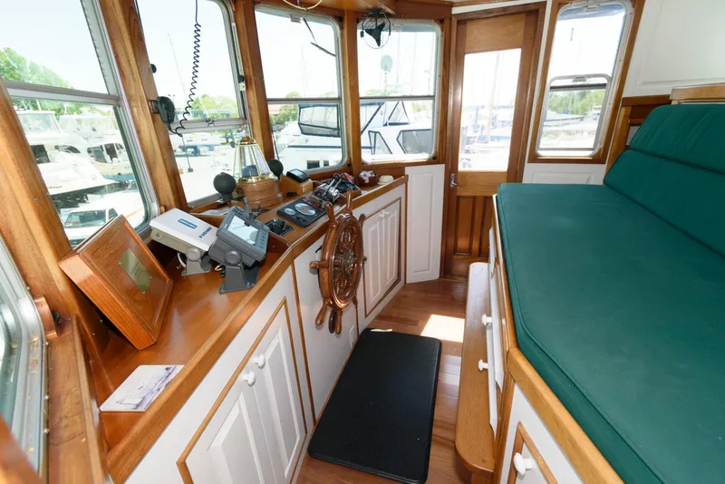 Slide: The Image of Interior of a 1997 Florida Bay Coasters 35 boat with wooden helm and green seating. - 30