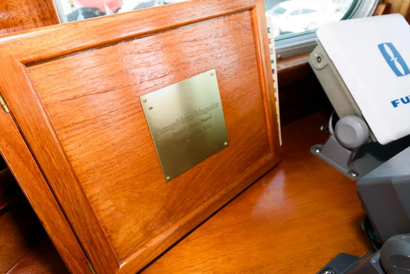 Slide: The Image of Wooden plaque with brass plate on 1997 Florida Bay Coasters 35 boat dashboard. - 31