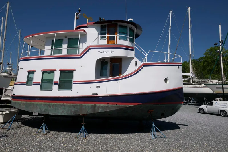 Slide: The Image of 1997 Florida Bay Coasters 35 boat, named "WaterLily," on dry dock with sailboats in background. - 5
