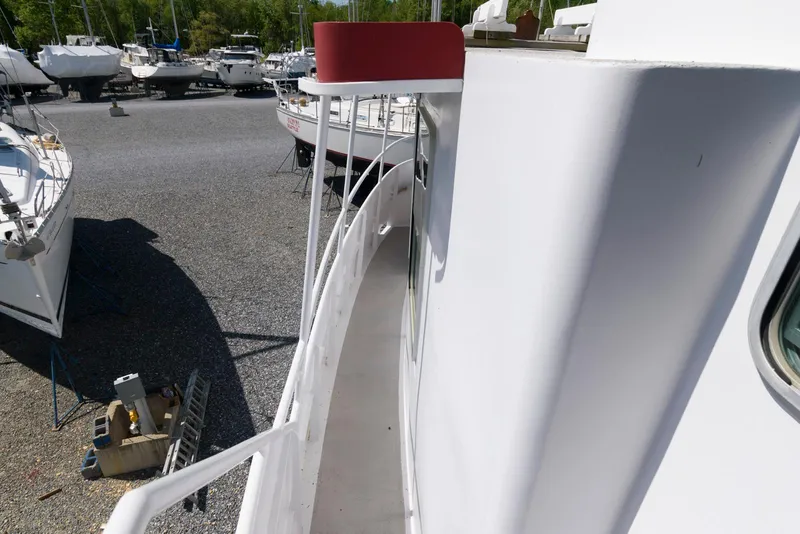 Slide: The Image of 1997 Florida Bay Coasters 35 boat on gravel lot with other vessels in background. - 7