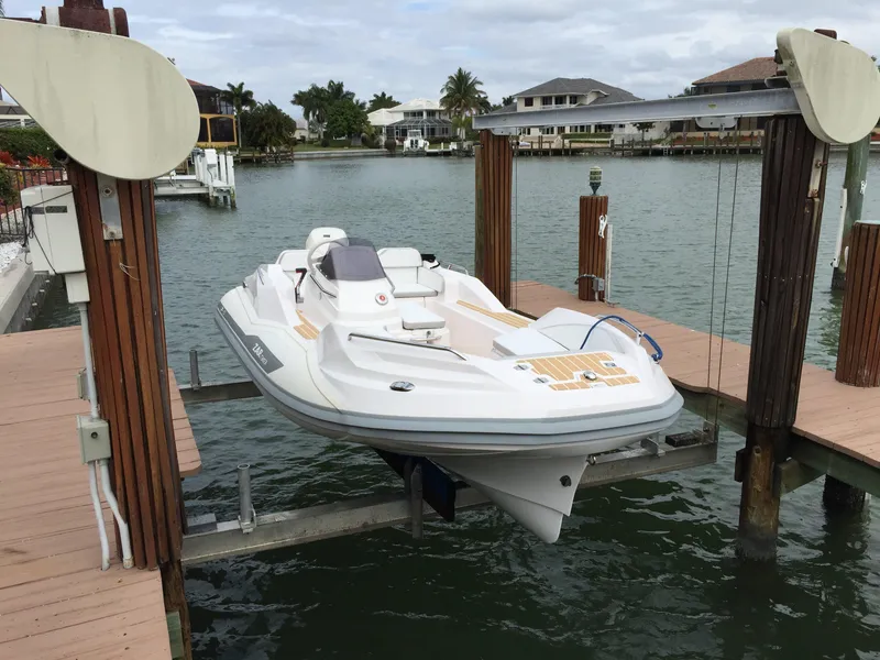 Slide: The Image of 2025 Zar Formenti ZF-5 boat on lift at waterfront dock, surrounded by houses and palm trees. - 15