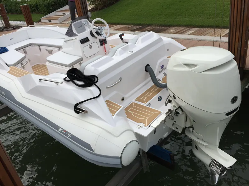 Slide: The Image of 2025 Zar Formenti ZF-5 boat with outboard motor, docked on calm water. - 16