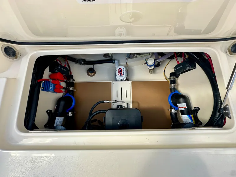 Slide: The Image of 2025 Scout 277 LXF boat compartment showcasing electrical and plumbing components. - 13