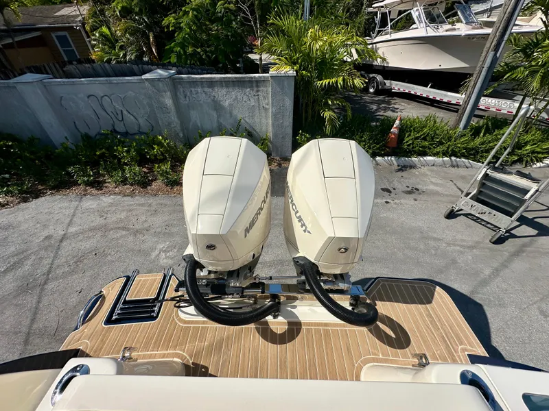 Slide: The Image of 2025 Scout 277 LXF boat with dual Mercury outboard engines, docked on a sunny day. - 15